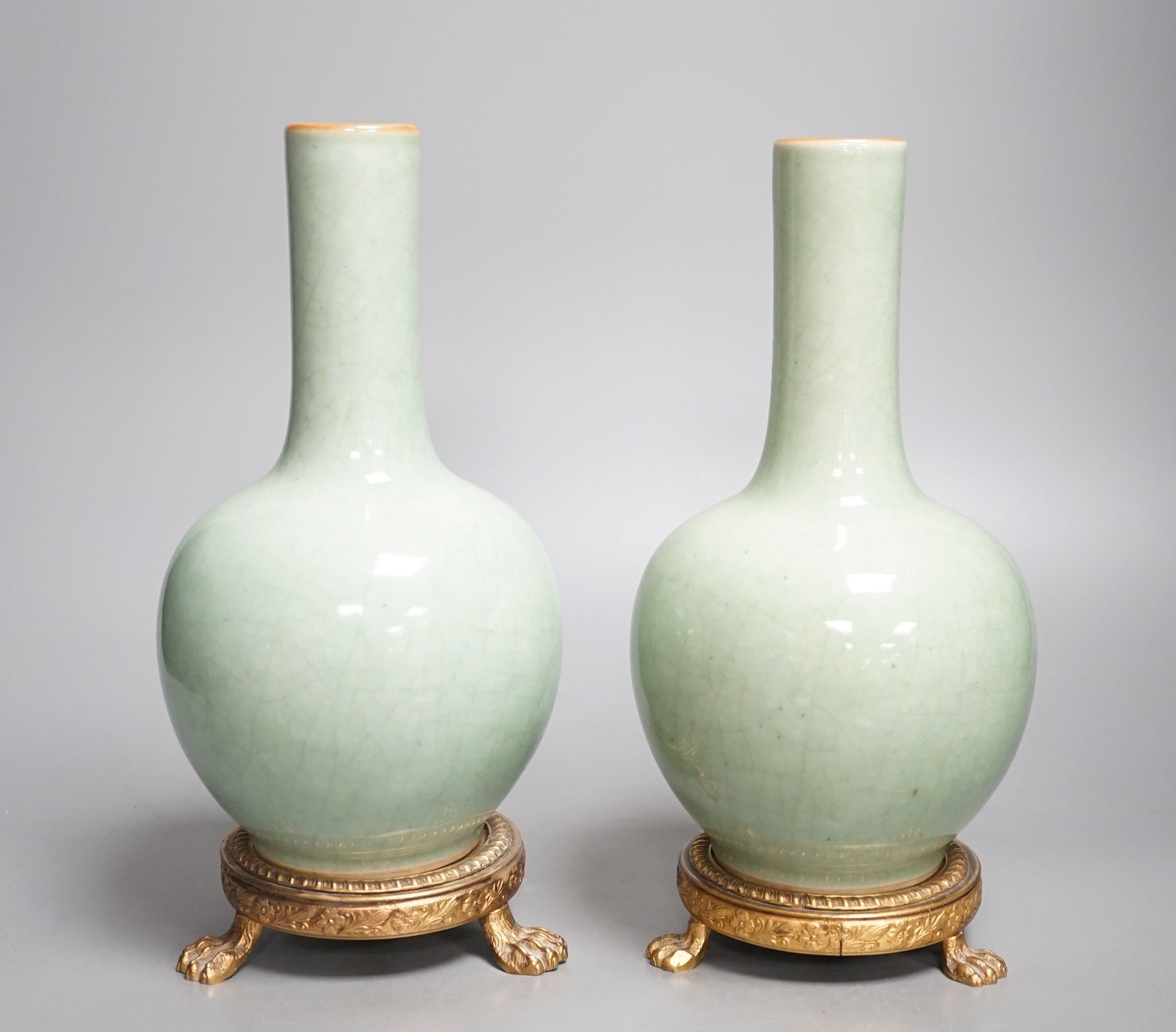 A pair of Chinese celadon crackle glazed bottle vases with gilt metal stands total height 27cm, bases drilled